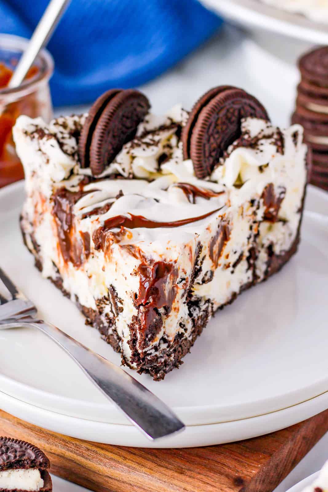 Straight on photo of a slice of Oreo Ice Cream Pie on white plate with whipped cream and oreos.