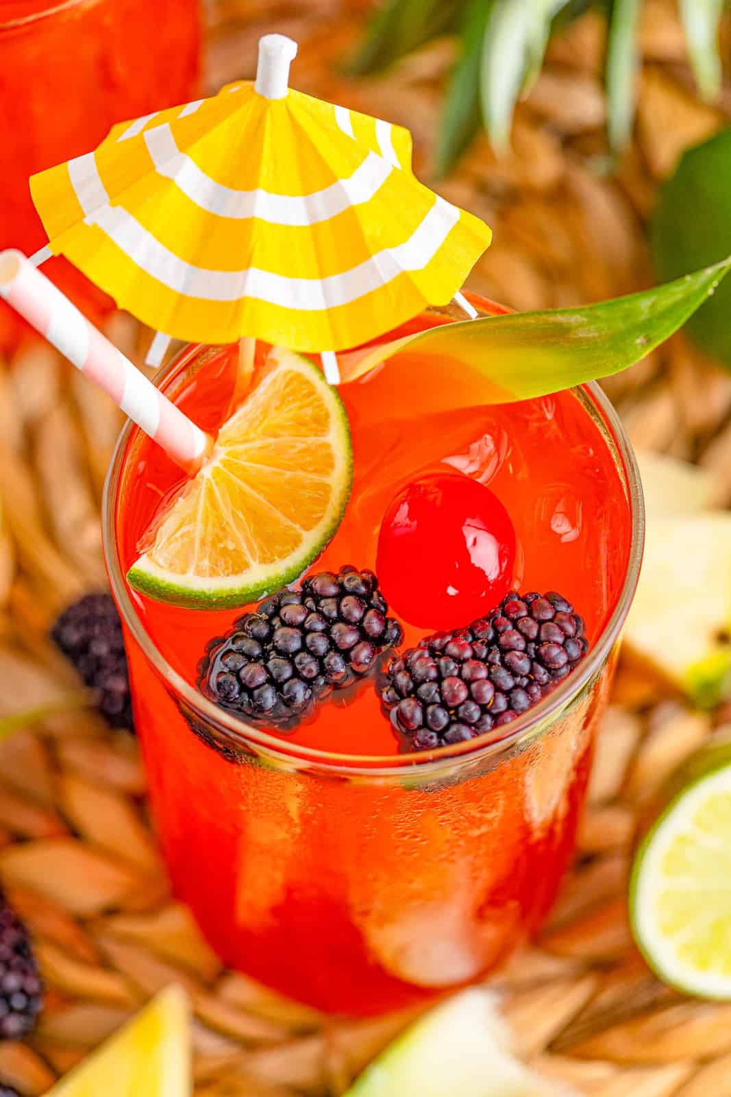 Overhead of a Rum Runner garnished with fruit and a yellow umbrella.