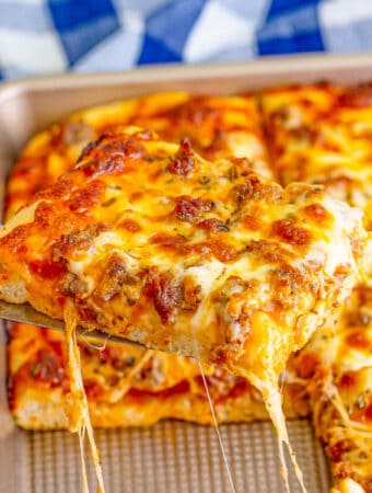 Square image of pizza slice being lifted out of pan.