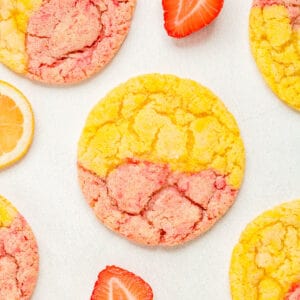 Square image of cookies on parchment paper with strawberries and lemons.