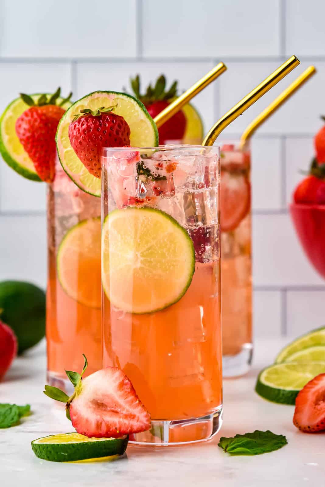 Close up of Strawberry Mojito in glasses garnished with straws.