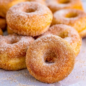Square image close up of Mini Donuts on parchment paper.
