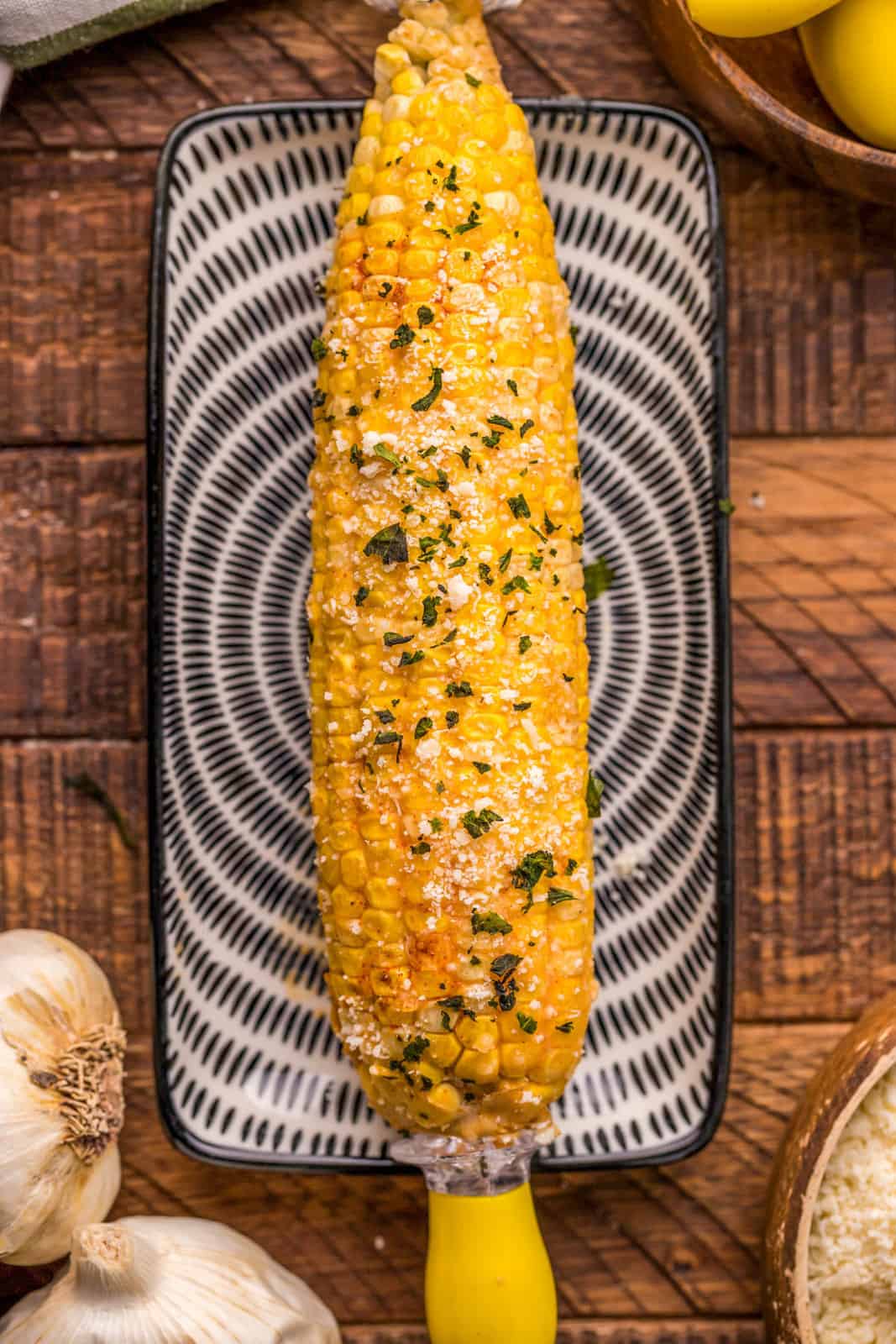 One piece of Smoked Corn on the Cob on small plate.