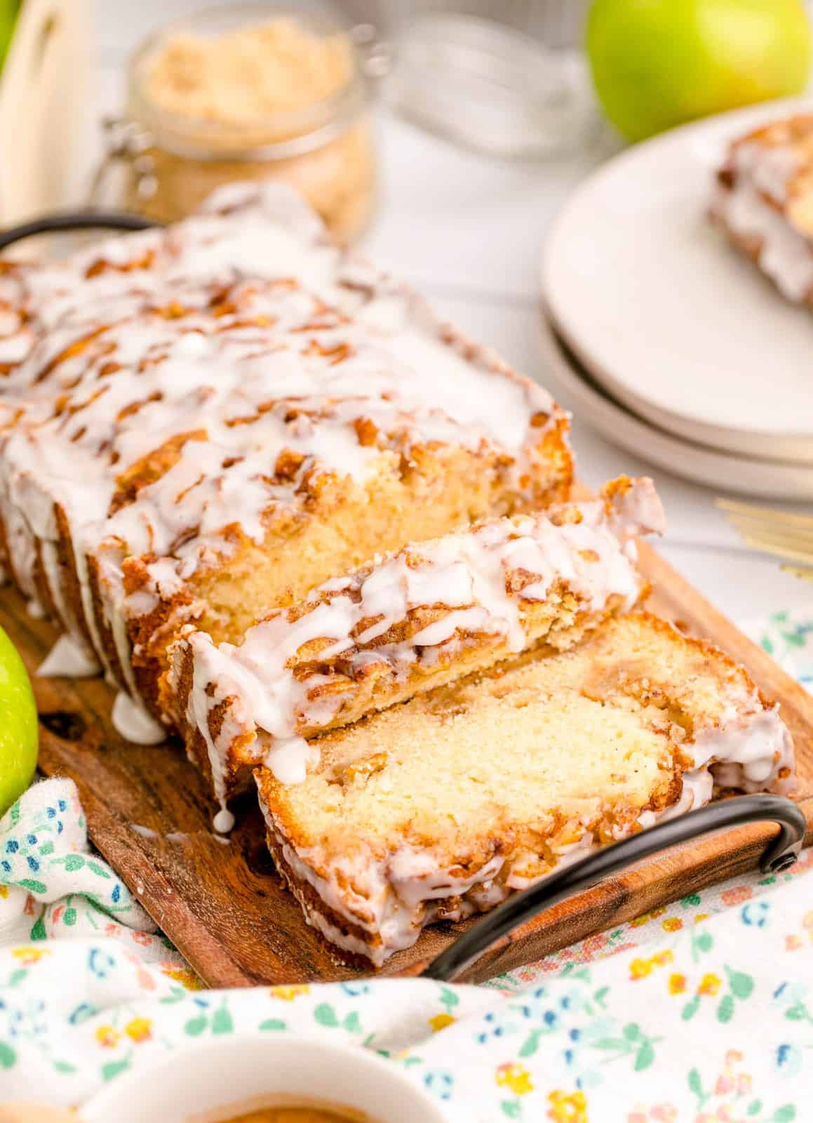 Slice Apple Fritter Bread on wooden board with glaze.