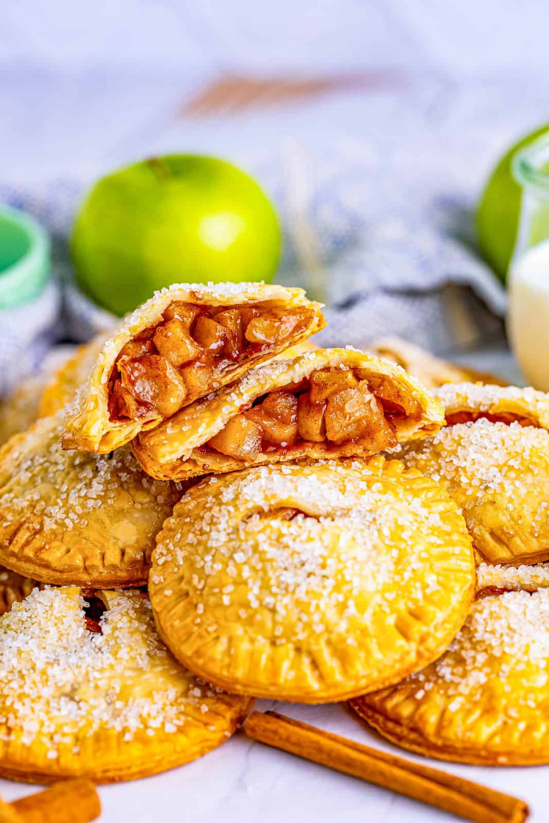 Stacked Apple Hand Pies with top one cut in half showing inside.
