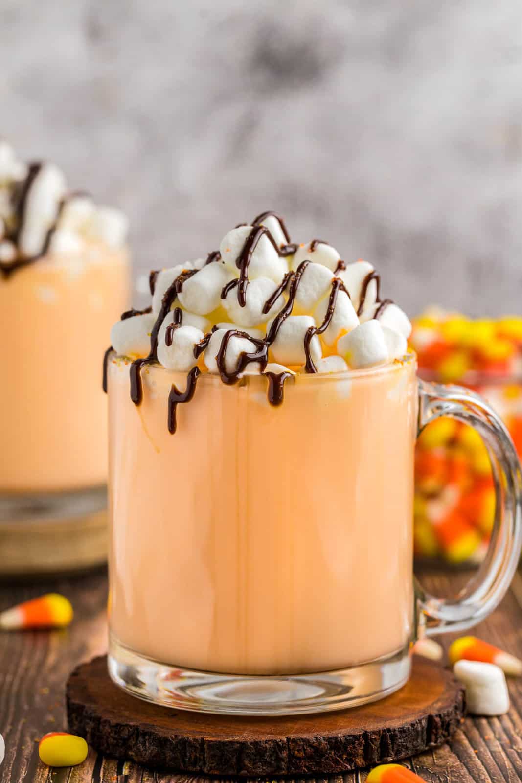 Close up of garnished Candy Corn Hot Chocolate on coaster with garnishes.