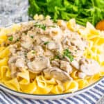 Square image of stroganoff on plate over noodles.