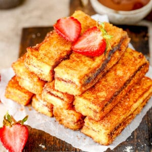 Overhead image of stacked French Toast Sticks on one another with strawberries.
