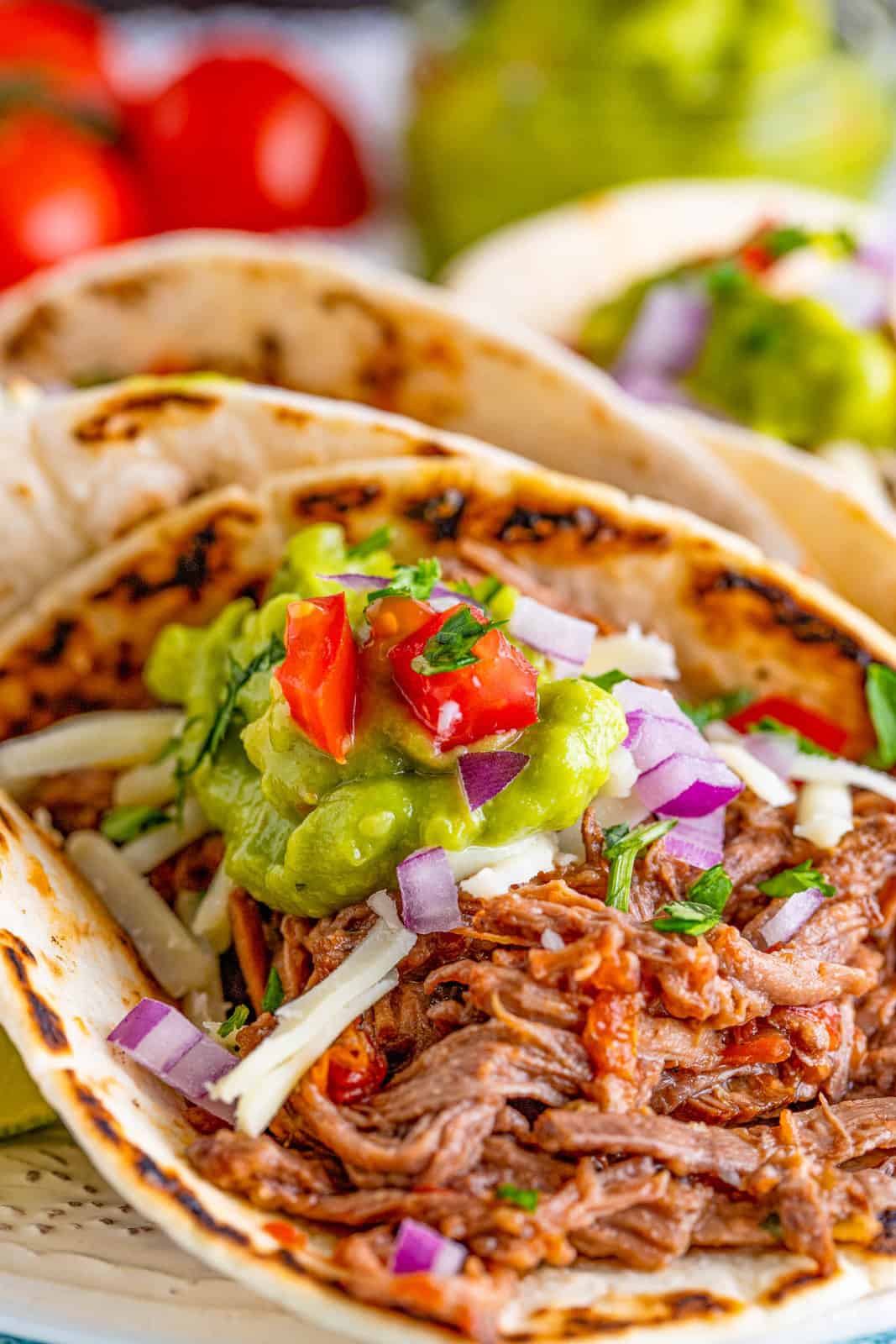 Close up of one taco showing toppings and shredded meat.