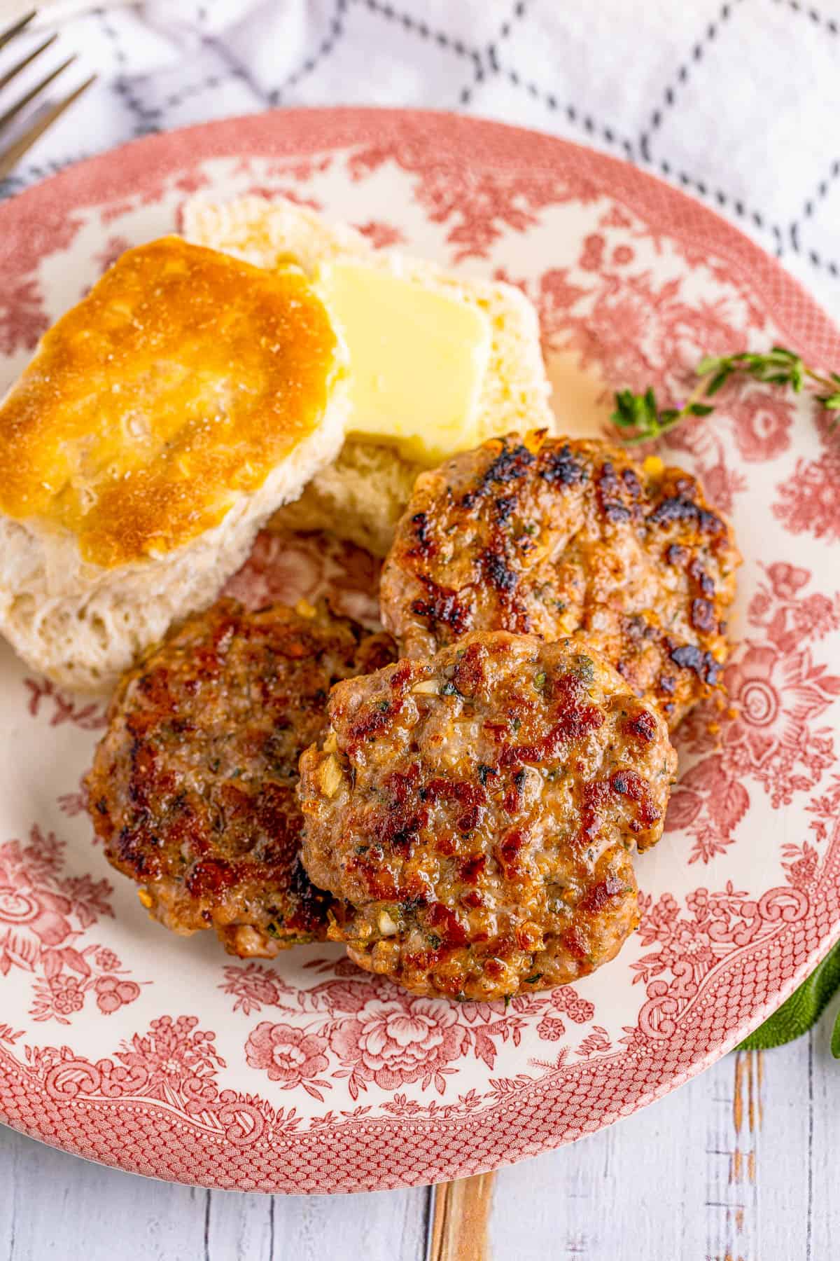 Overhead plate of Breakfast Sausage Recipe with biscuit and butter.