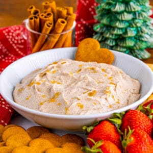 Square image of bowl with Cinnamon Roll Cheesecake Dip with dippers surrounding it.