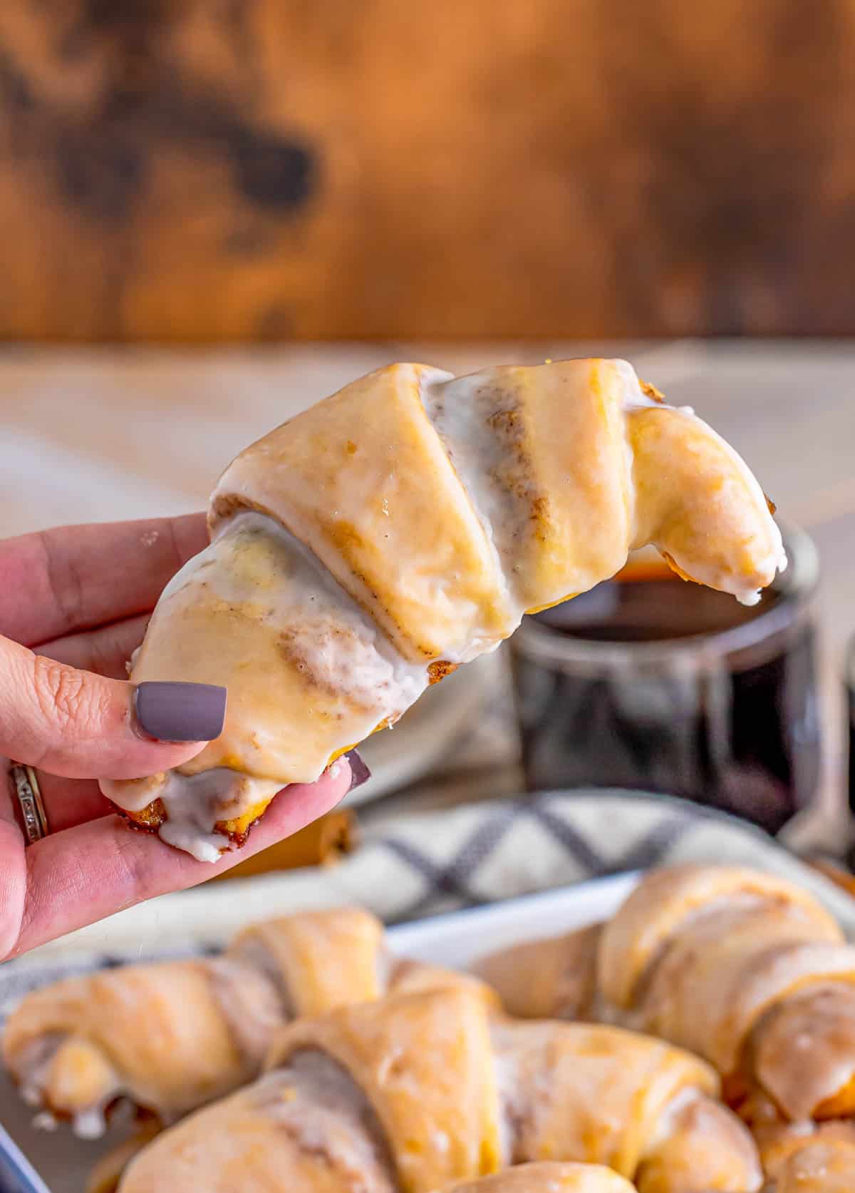Hand holding up one of the Cinnamon Crescent Rolls.
