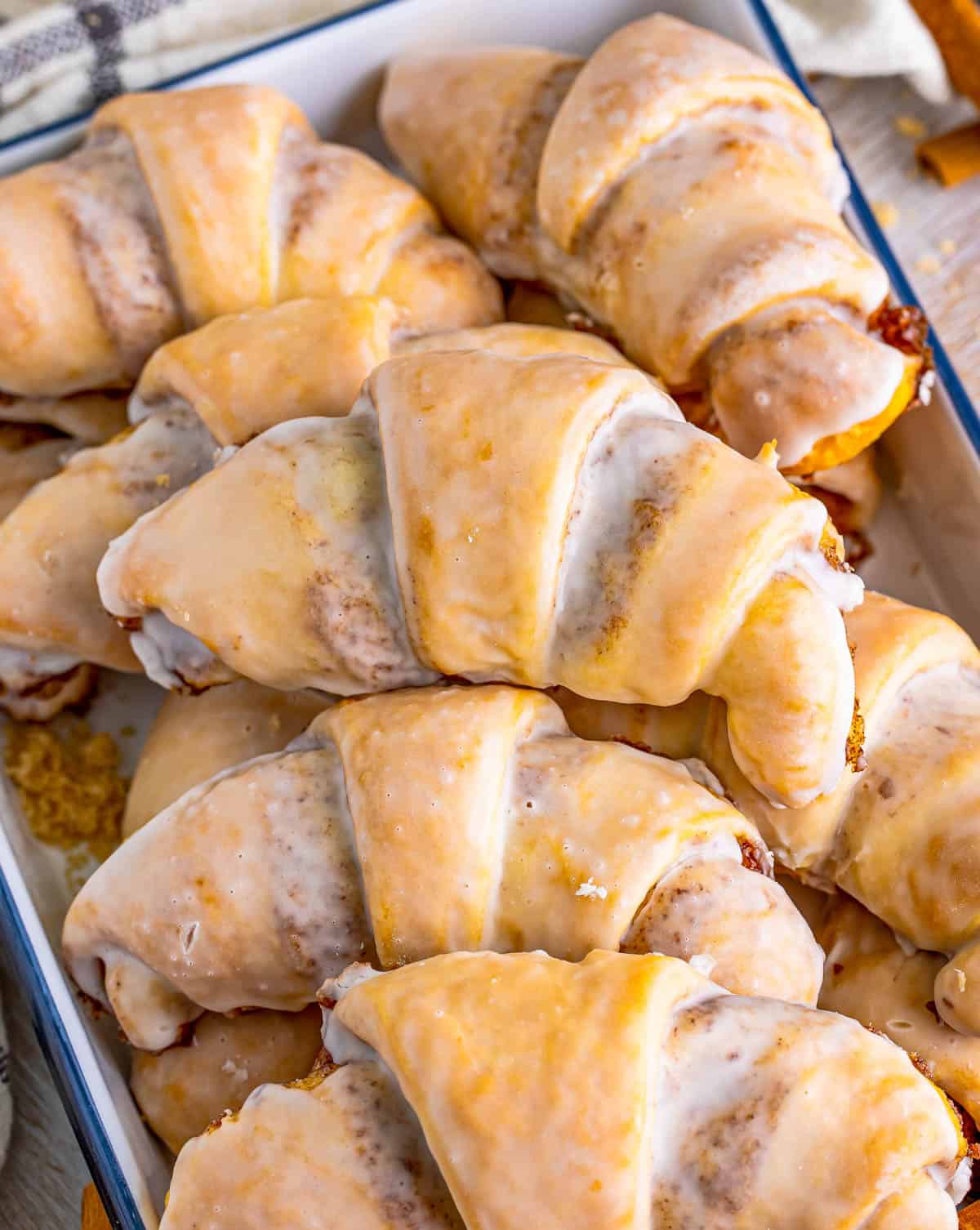 Overhead photos of stacked Cinnamon Crescent Rolls in tray.