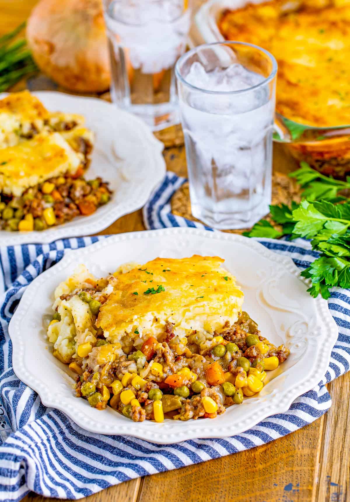 Easy Shepherd's Pie on plates with water and baking dish in background.