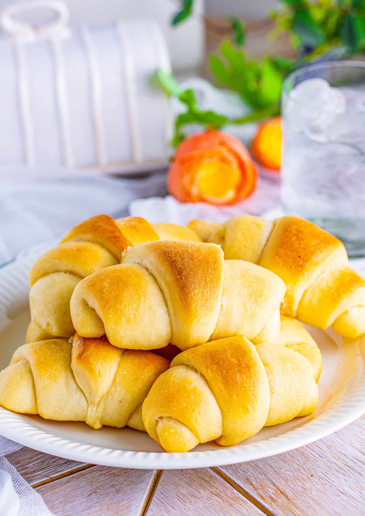 Crescent Rolls Recipe stacked on top of one another on white plate.