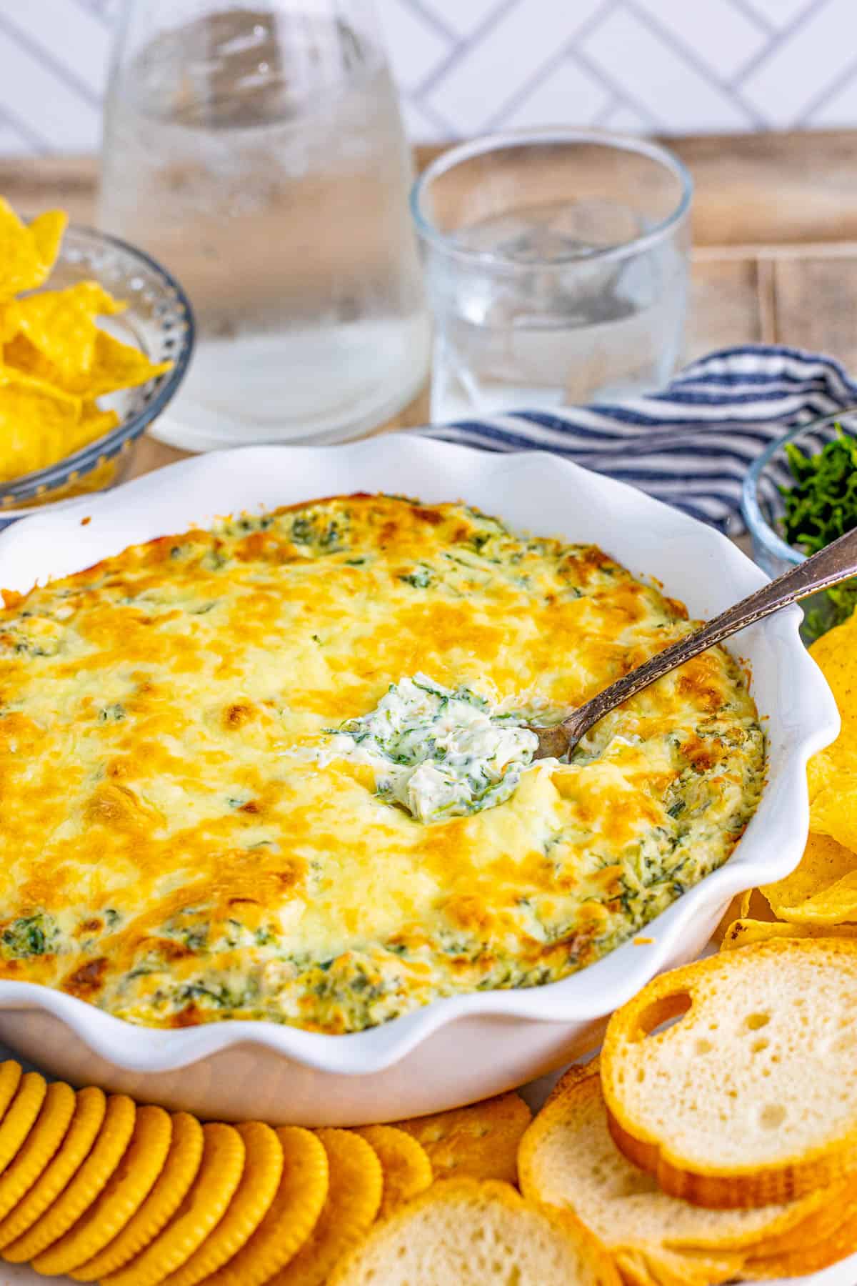 Serving spoon in pan with Hot Artichoke Spinach Dip.