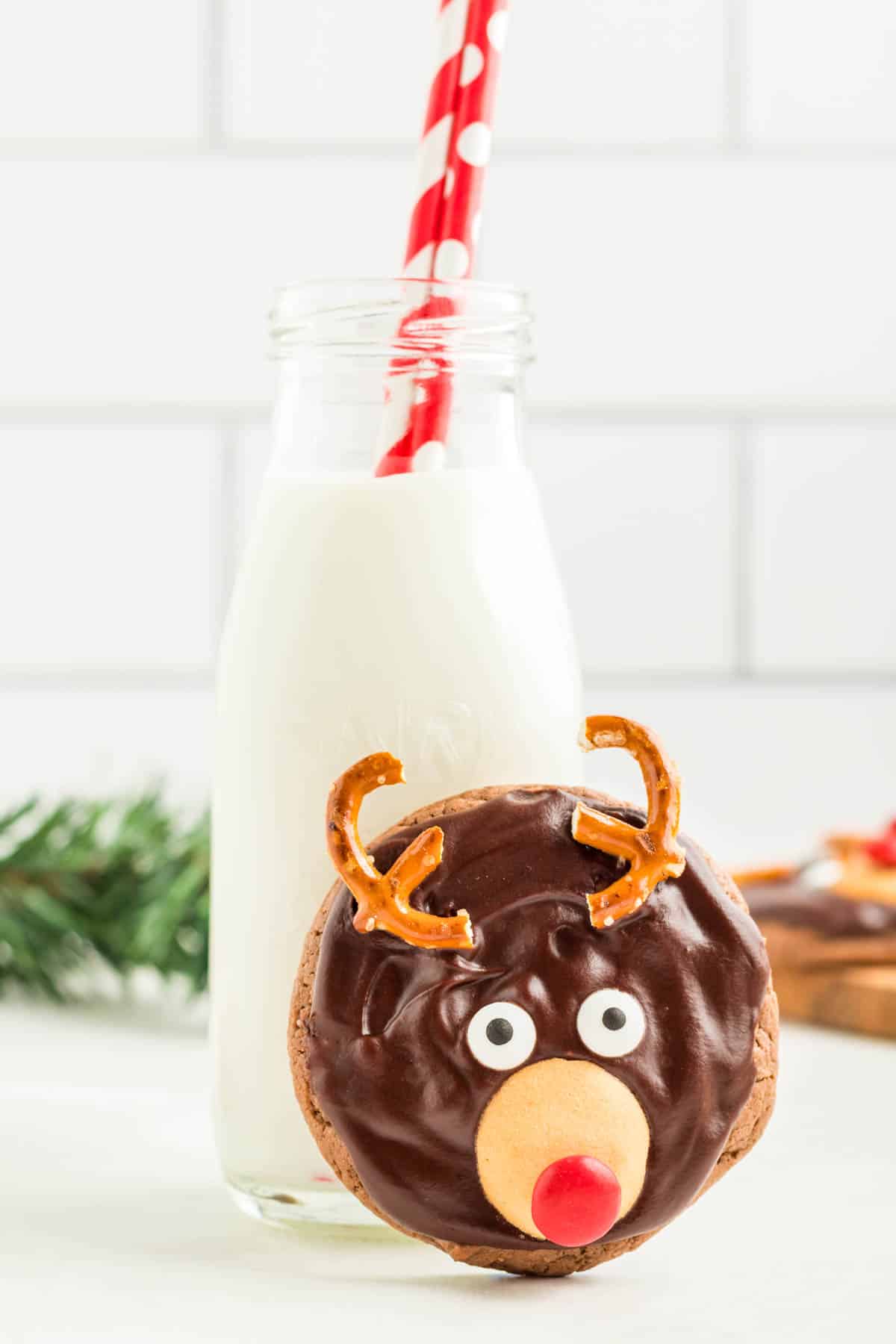One of the Reindeer Cookies propped up against a glass of milk.