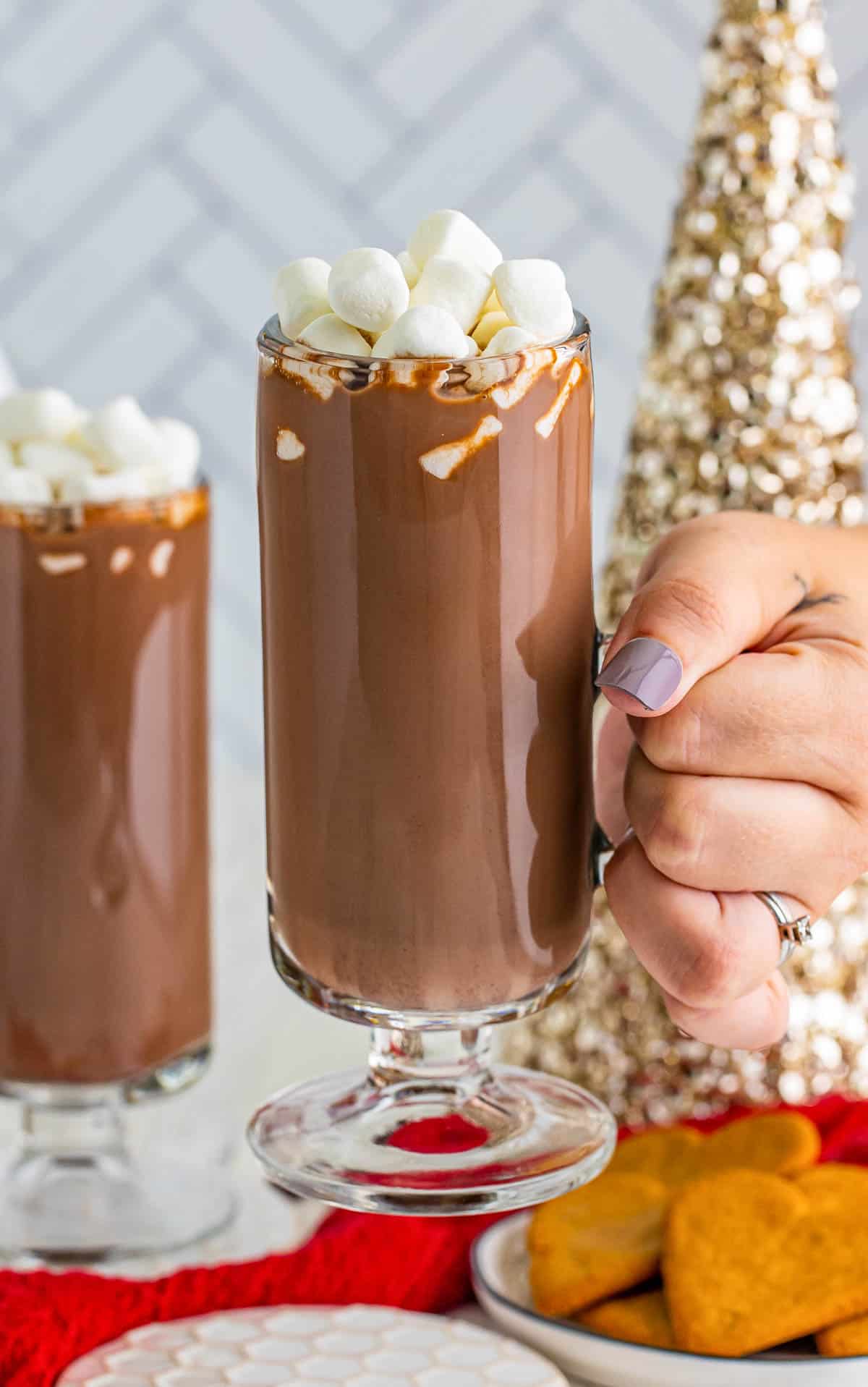 Hand holding up on glass of the RumChata Hot Chocolate.
