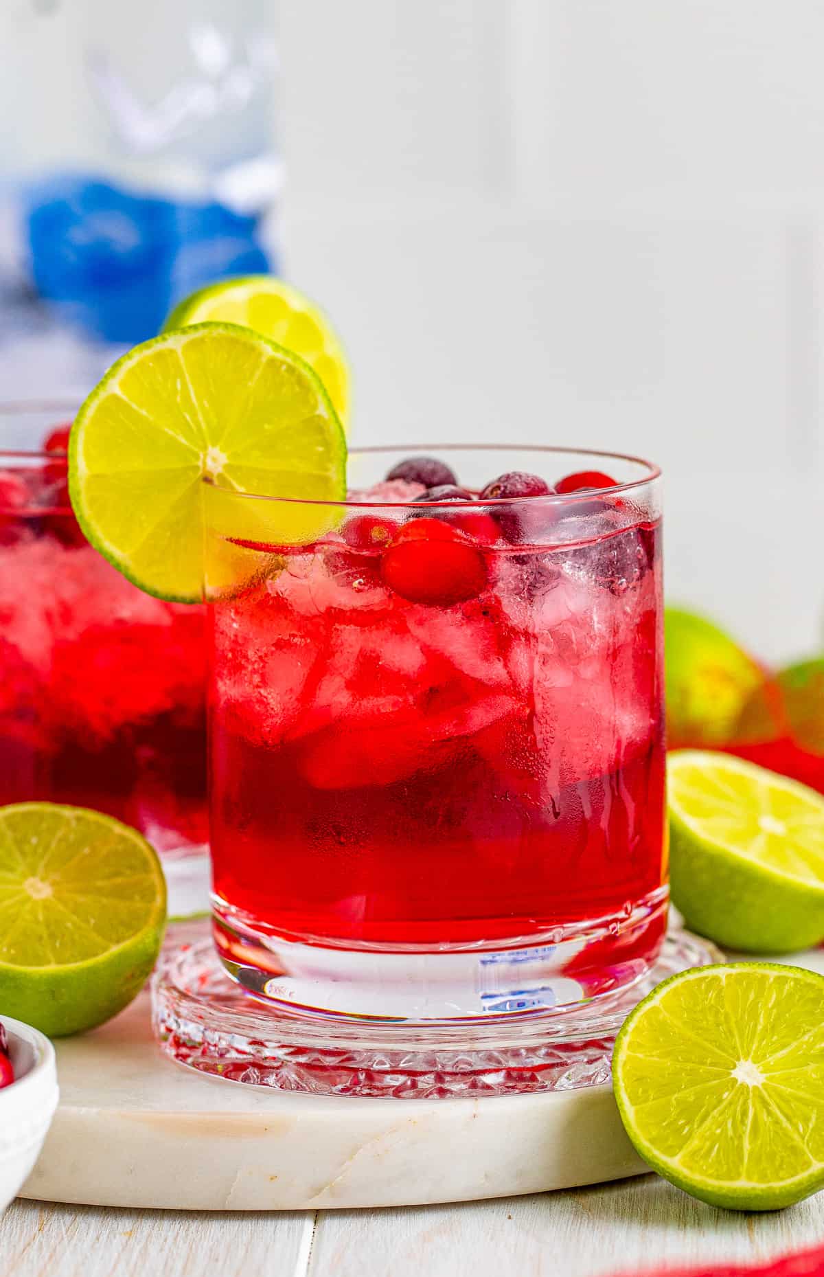 One Vodka Cranberry in glass with garnishes.