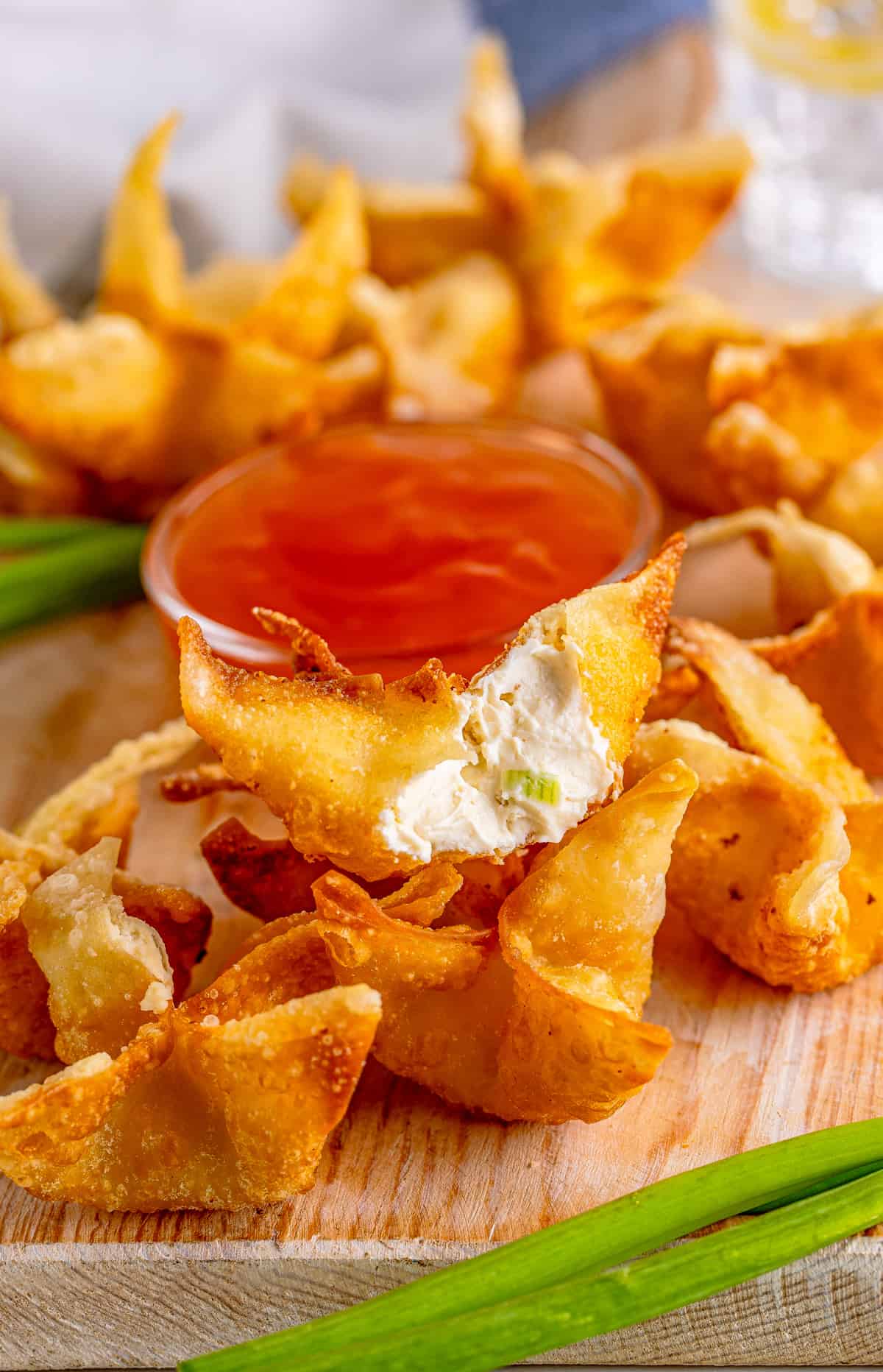 Stacked Cream Cheese Wontons with one showing the filling.