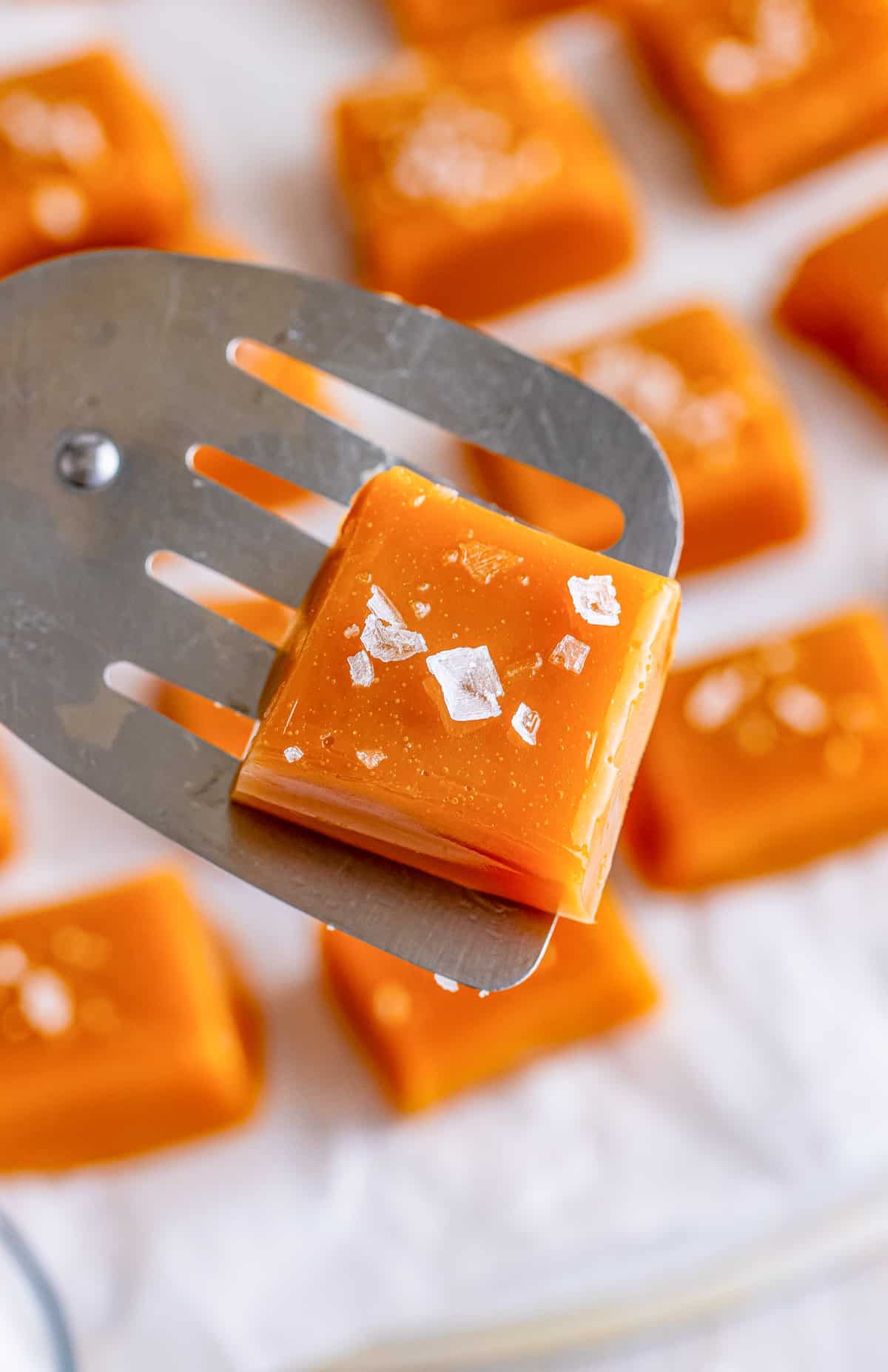 Spatula holding up one of the caramels showing salt.
