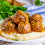 Close up square image of meatballs over mashed potatoes.
