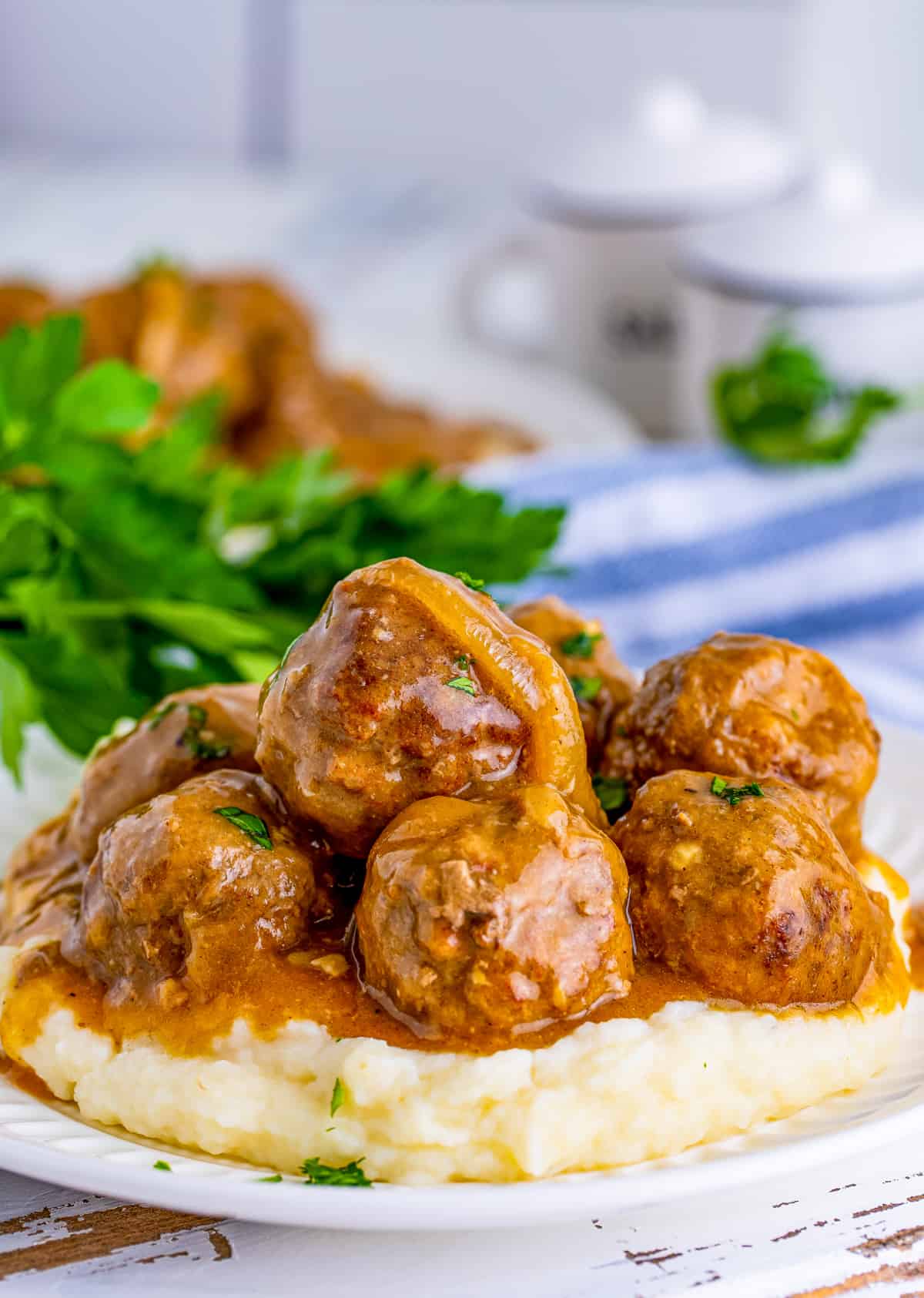 Meatballs with Gravy served over mashed potatoes on plate.