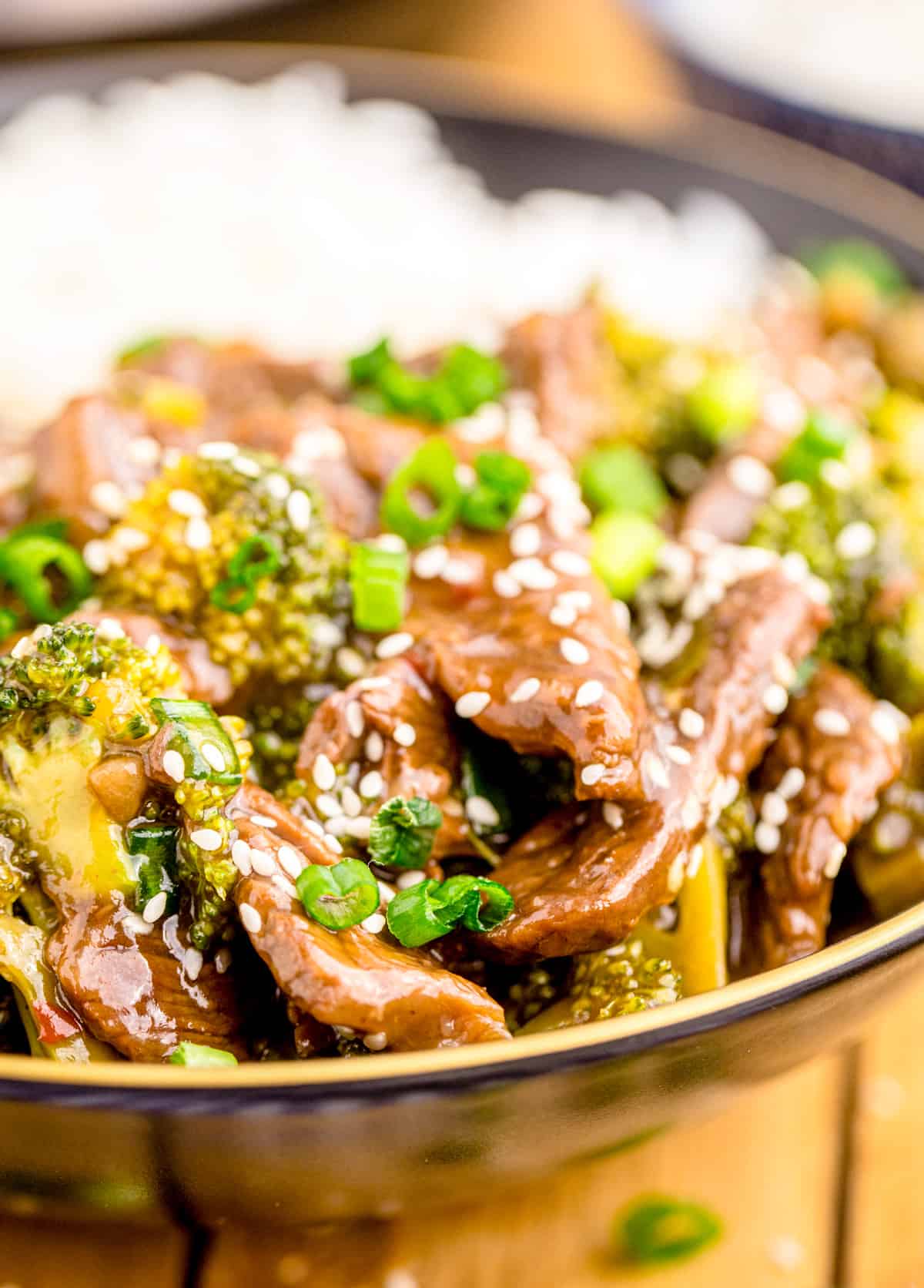 Close up of Instant Pot Beef and Broccoli in bowl showing the beef topped with sesame seeds.