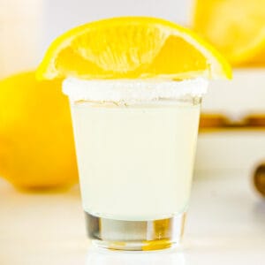 Close up square image of finished shot with glass rimmed with sugar and topped with a lemon wedge.