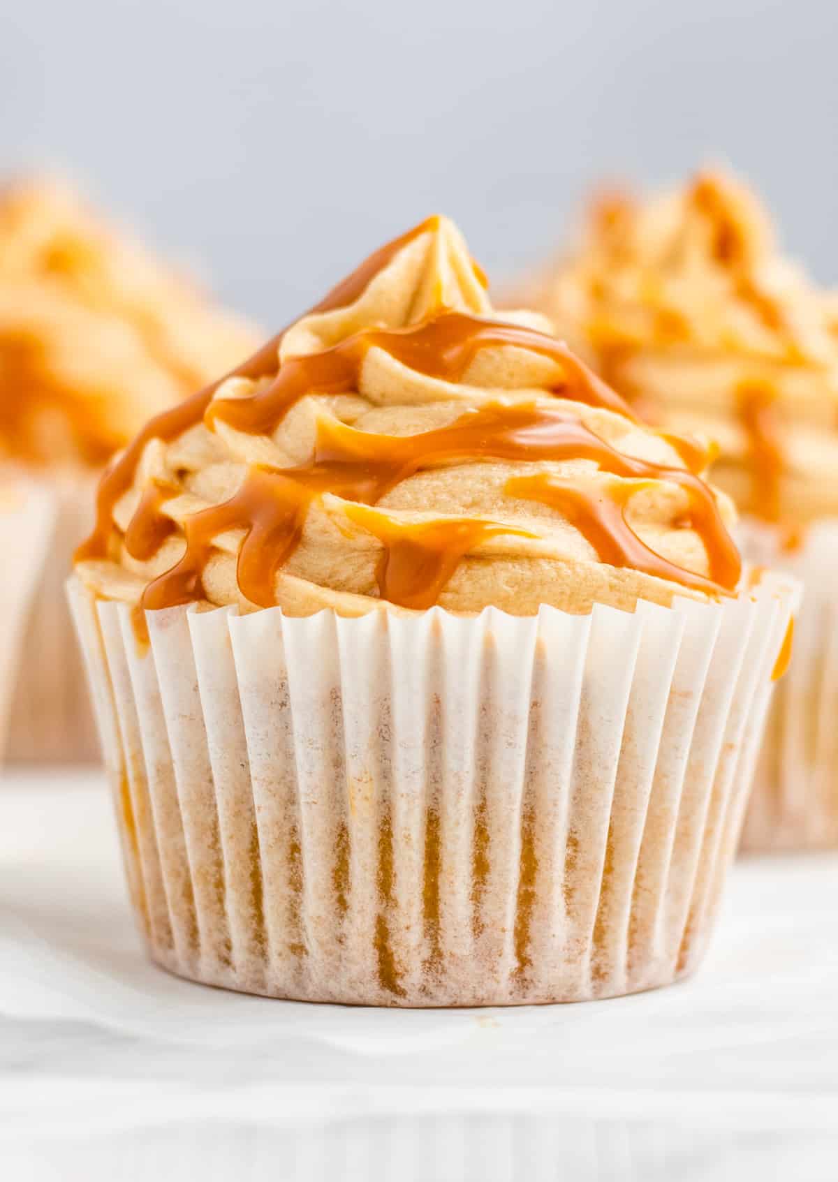 One finished Salted Caramel Cupcake close up frosted and drizzled with salted caramel.