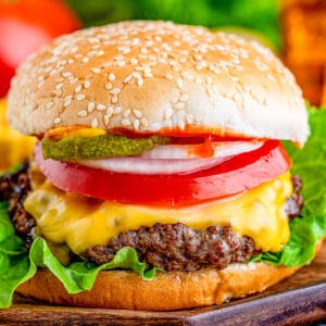 Close up of Cheeseburger with melted cheese and lots of topings.