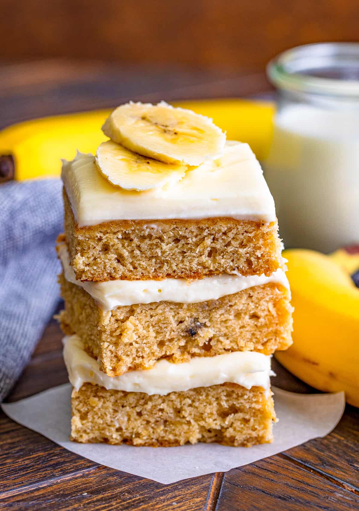 Three stacked Banana Blondies on top of one another on piece of parchment paper.