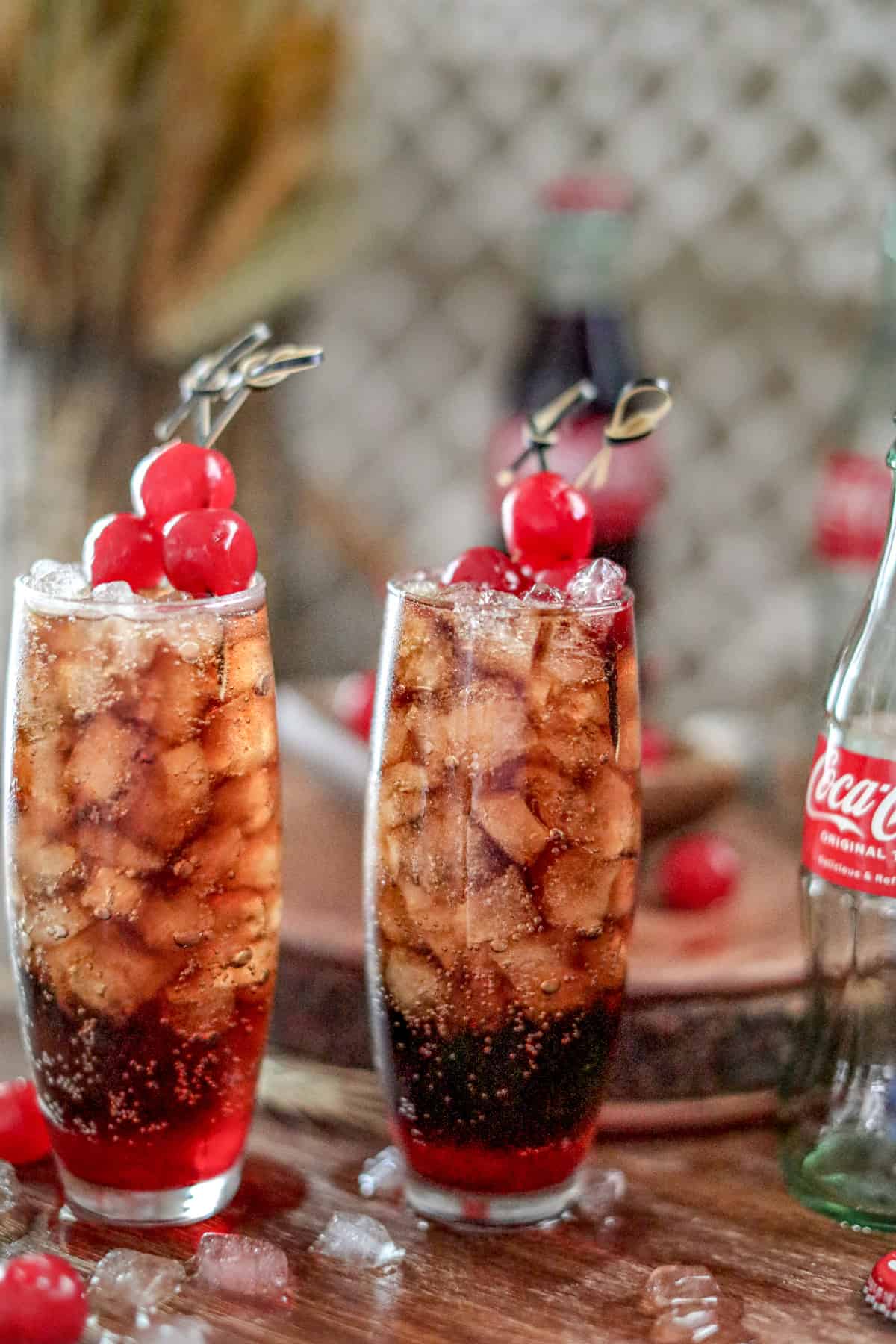Two of the Roy Rogers Drink in tall glasses showing the ice and cherries on toothpicks.
