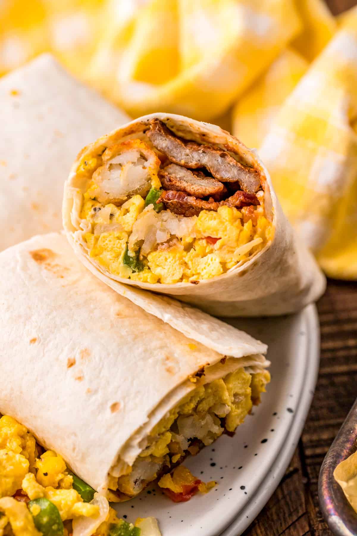 Breakfast Burrito Recipe cut in half with one half propped up on the other showing the inside.