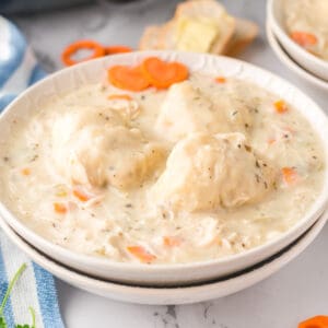 Close up square image of chicken and dumplings in whit ebowl.