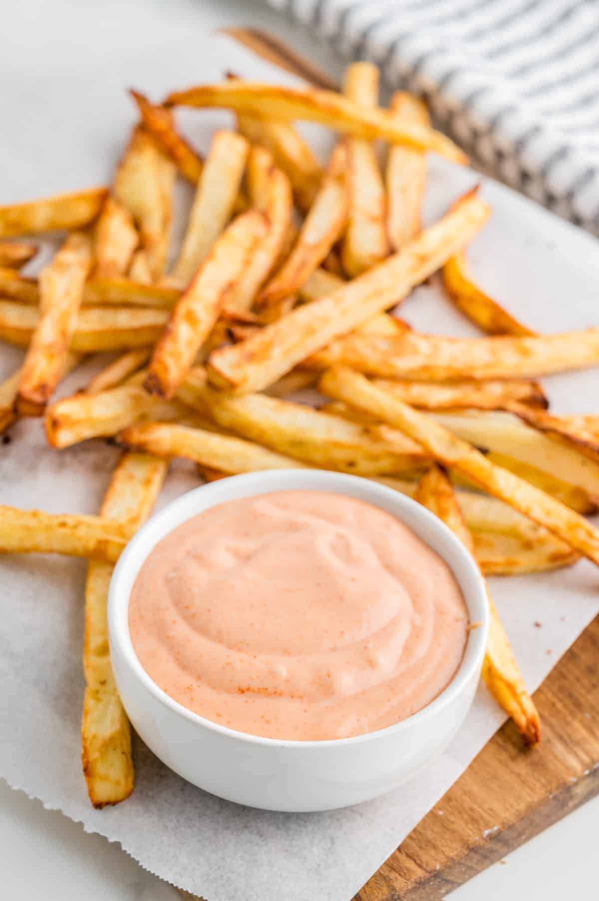 Fry Sauce in white bowl on parchment paper surrounded by french fries.