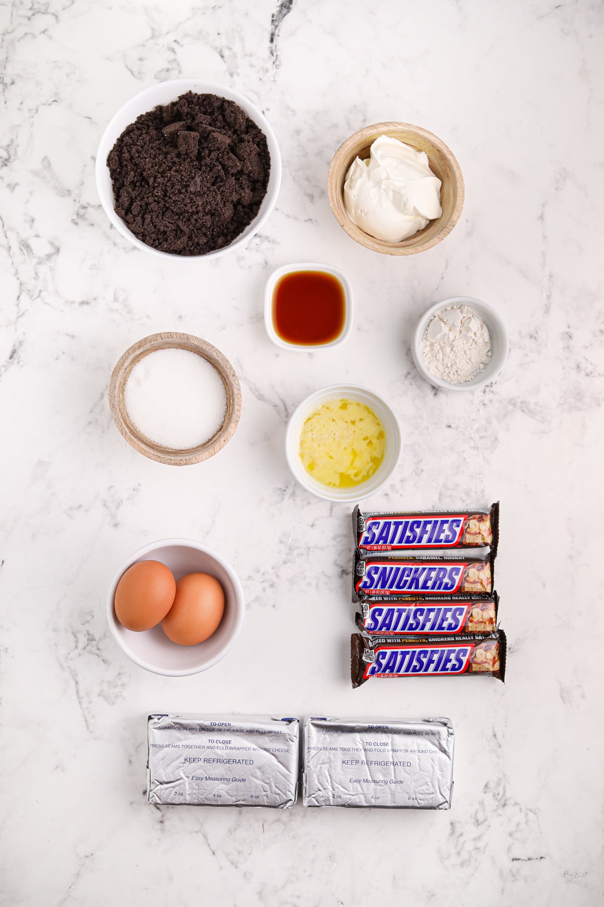 Ingredients needed to make Snickers Mini Cheesecakes.