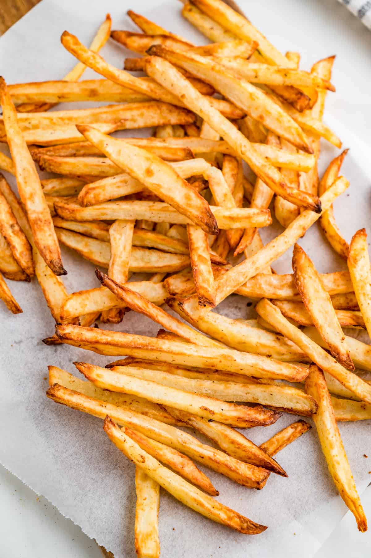 Air Fryer French Fries on parchment paper right after cooking.