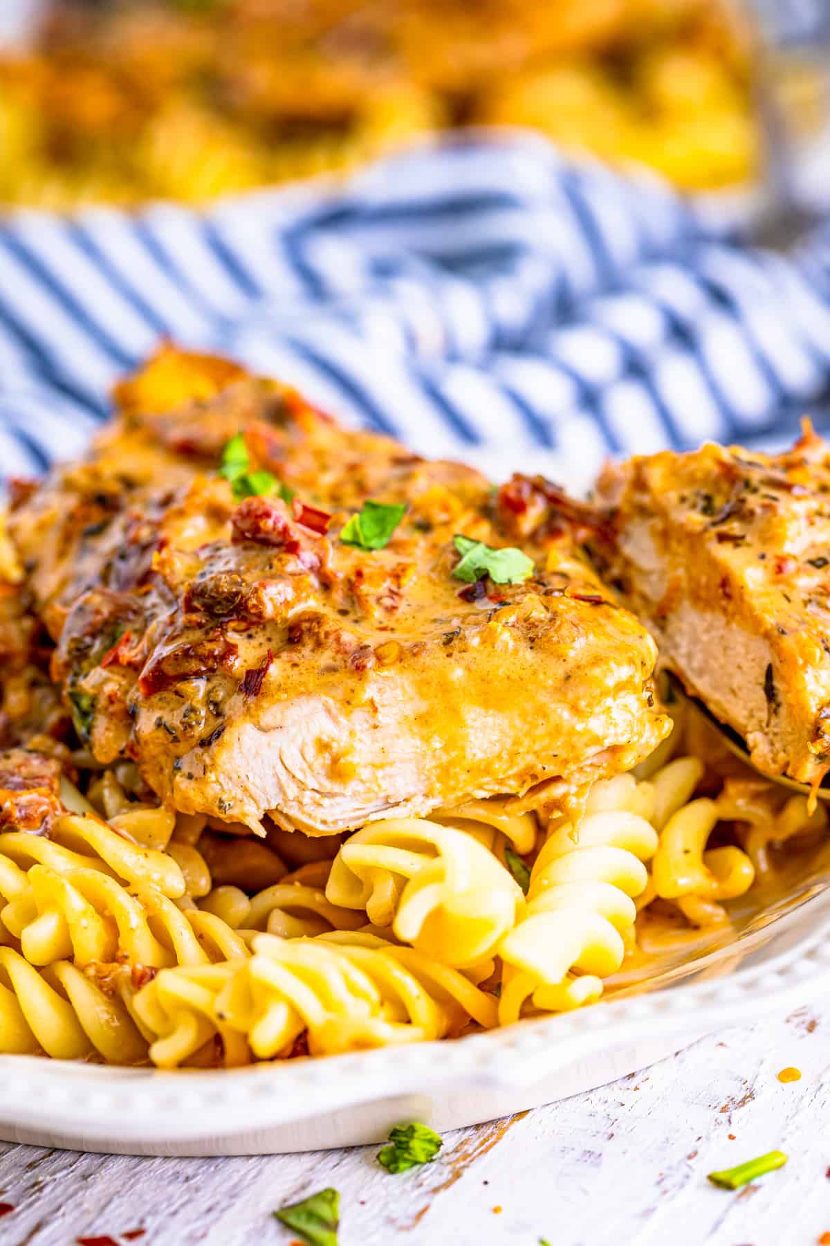 Chicken over noodles cut so you can see the juicy cooked inside.