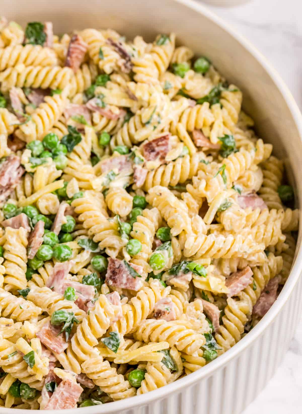 Bacon Ranch Pasta Salad close up in white ridged serving bowl.