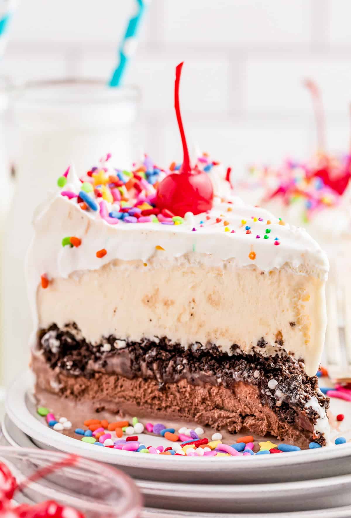 One slice of the Copycat Dairy Queen Ice Cream Cake on a white cake showing the layers and toppings.