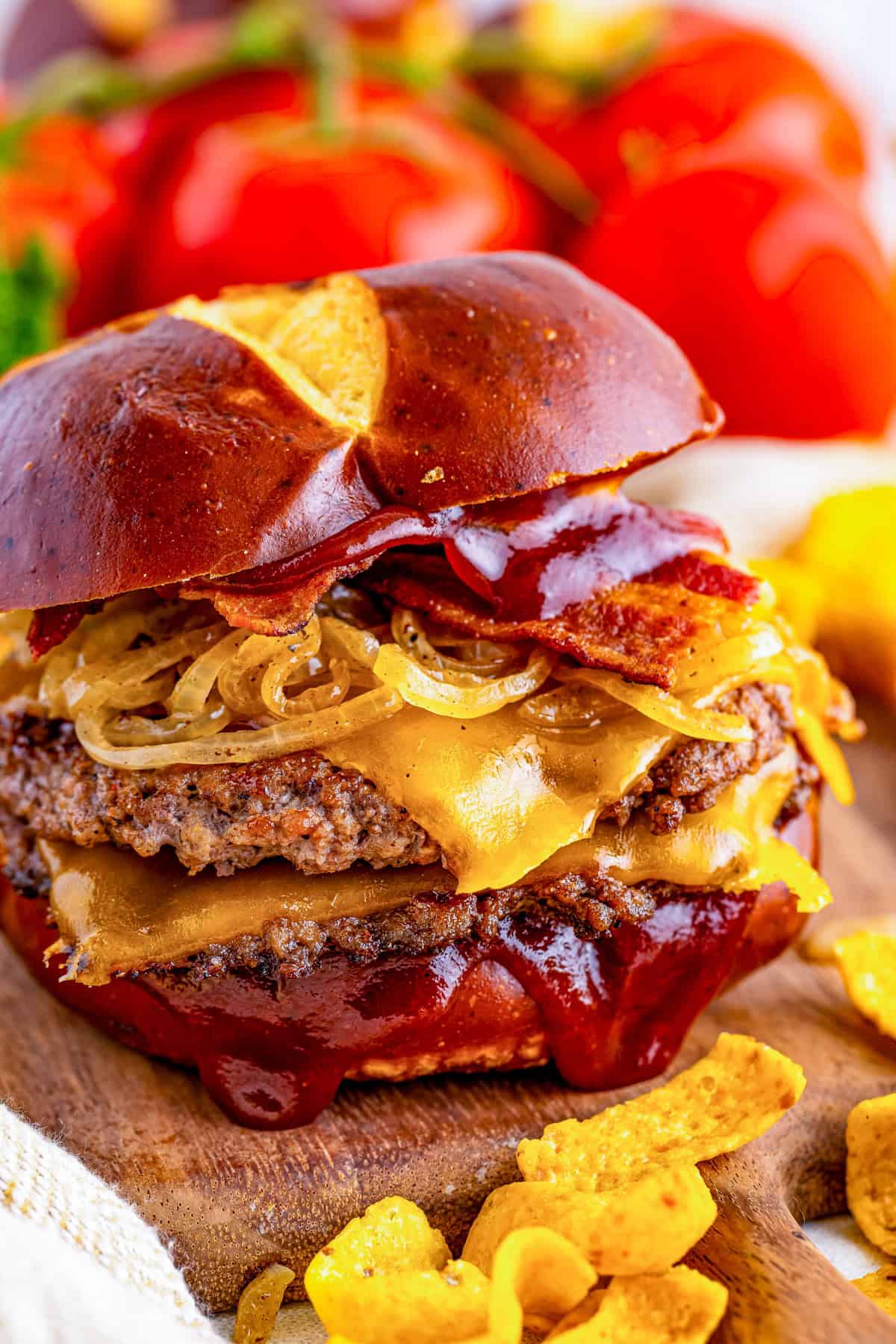 BBQ Bacon Burger with two patties topped with onions, bacon and bbq sauce on a pretzel bun.