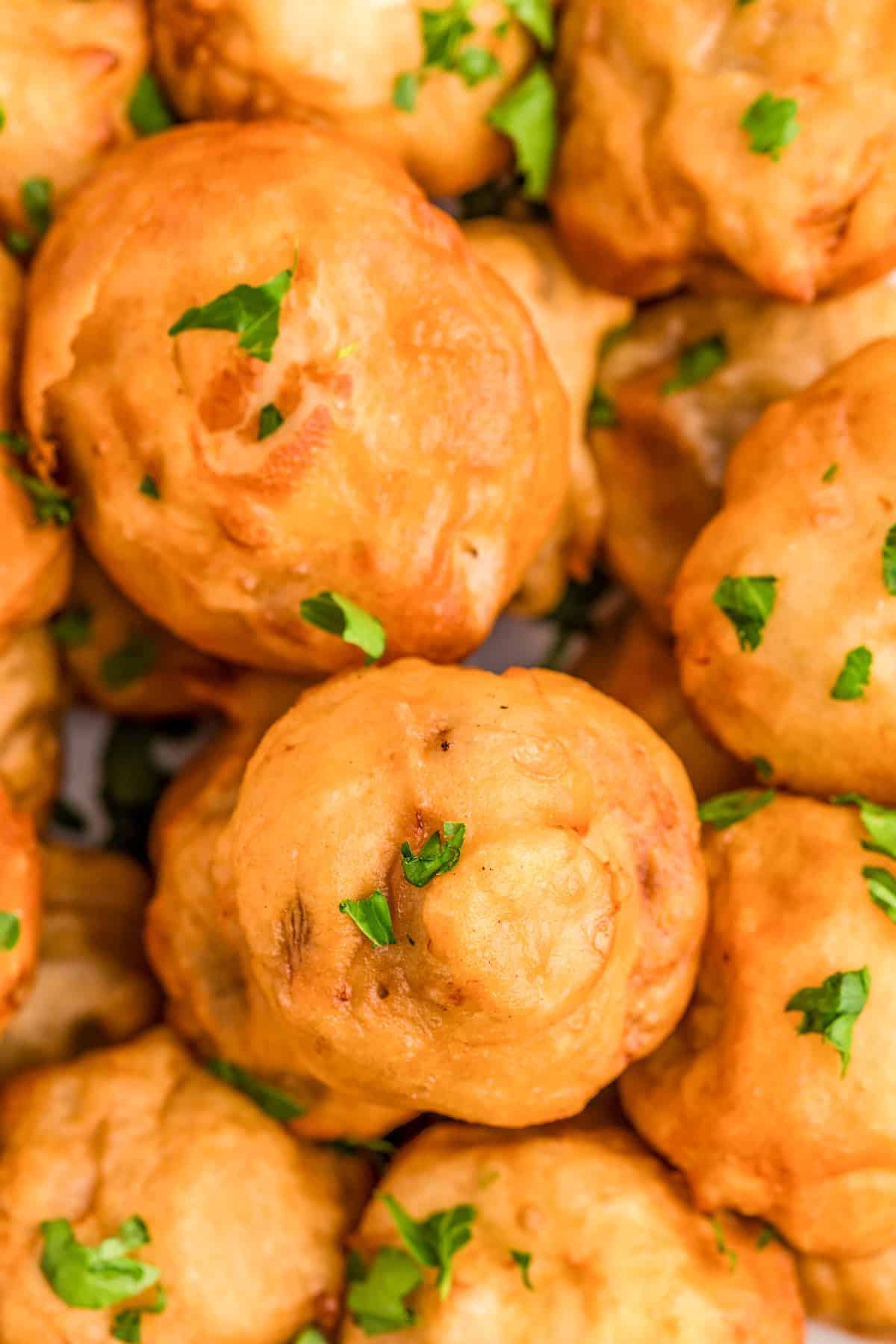 Close up of finished and stacked Fried Mushrooms with parsley.