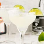 Close up square image of finished margarita garnished with salt and lime.