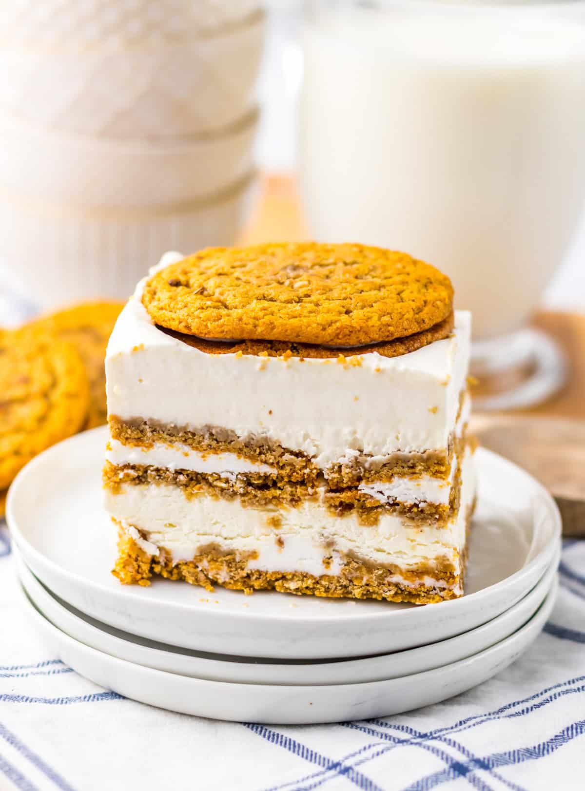 One of the Oatmeal Cream Pie Ice Cream Sandwiches on stacked white plates showing the layers of oatmeal cream pies with milk in background.