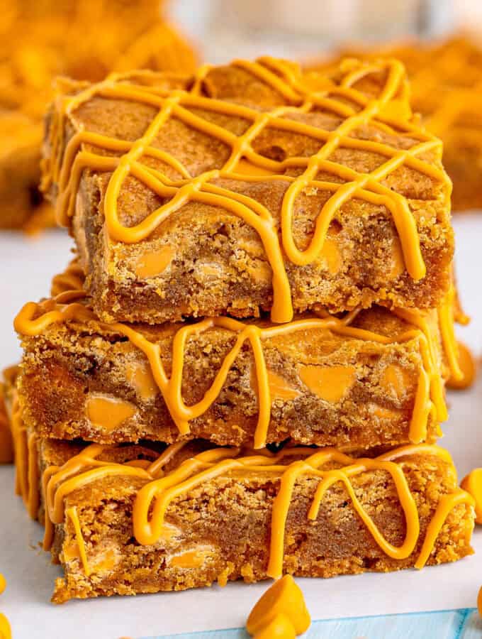 Close up of three stacked blondies on top of one another showing the butterscotch drizzle.