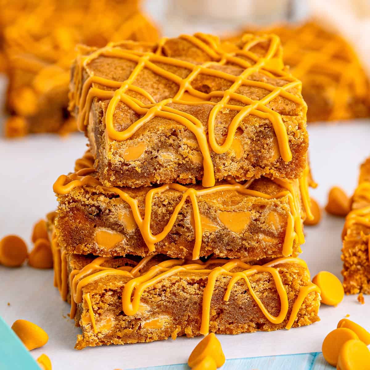 Close up of three stacked blondies on top of one another showing the butterscotch drizzle.