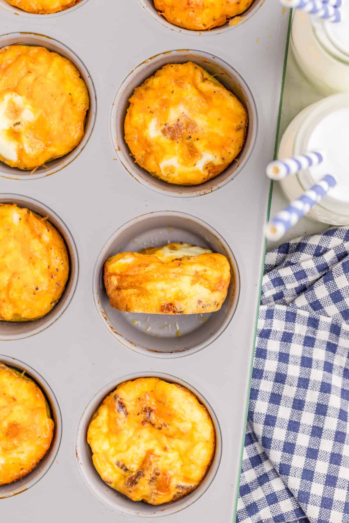 Overhead of eggs finished in baking pan with one on its side.