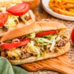 Close up square image of sandwich on wooden board showing all the toppings.