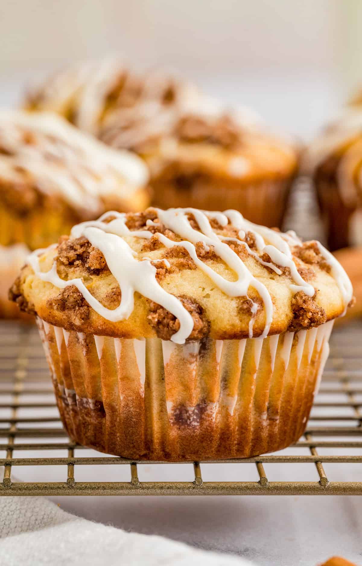 Cinnamon Roll Muffins on wire rack topped with the cream cheese glaze.